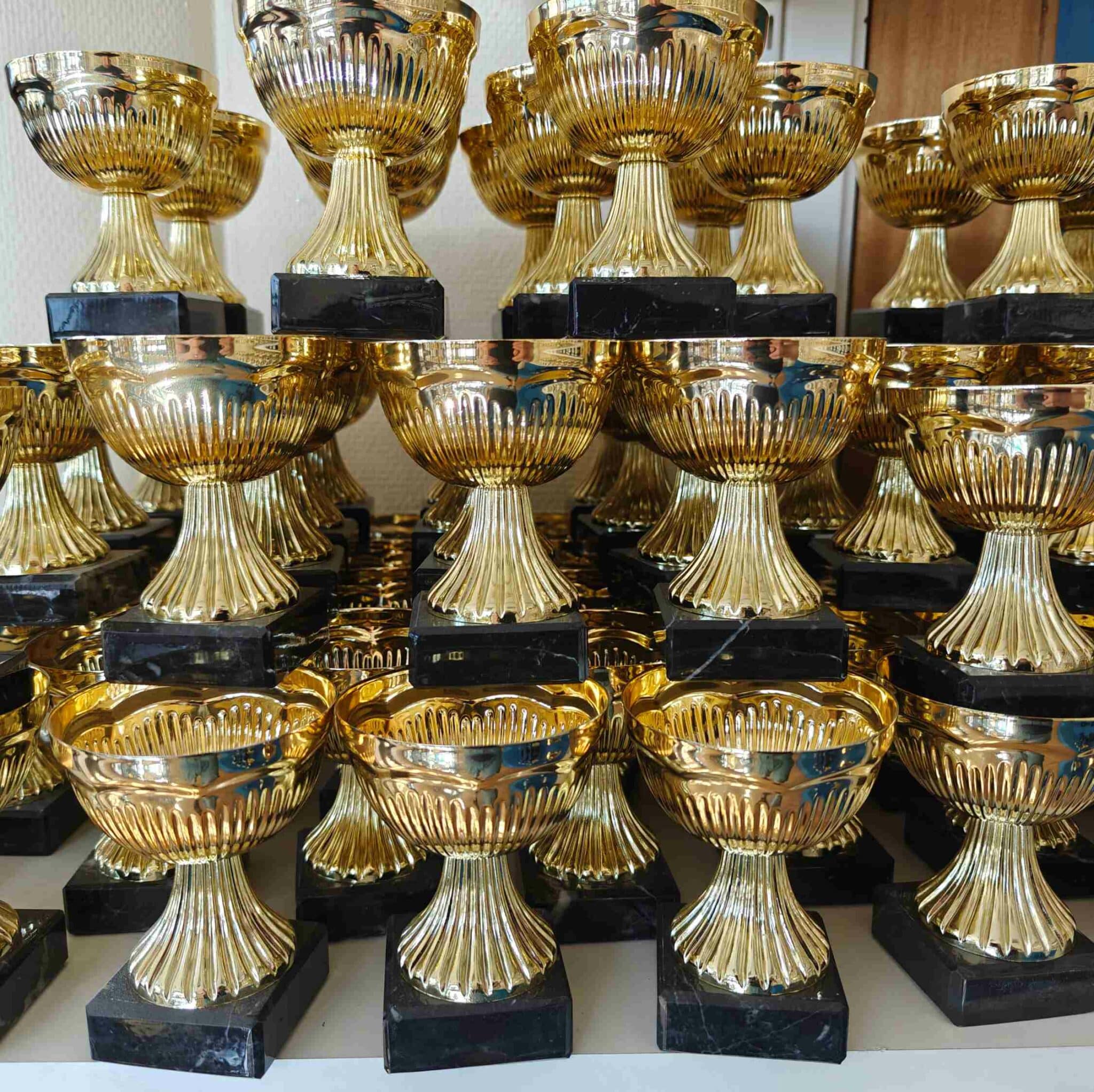 Småpokaler i guld med svart marmorsockel